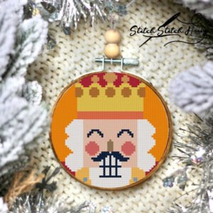 Tree Ornament Orange Nutcracker Cross Stitch Pattern featuring a royal soldier with a golden crown for Christmas crafting