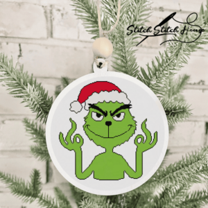 Funny Grinch wearing Santa hat making a snarky hand gesture handmade cross stitch pattern design
